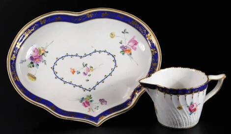 A Derby cream jug, with wishbone handle, decorated with a Smith's blue band and gilding above flower sprays, blue crown over D mark, 6.5cm H, a small Derby kidney shaped dish, blue marked crown over D mark, decorated with a Smith's blue border and gilt gr