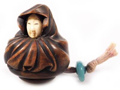 A Japanese Taisho period ivory and hardwood netsuke, carved as a lady in a shawl, with stringing and glass fastener, unmarked, 6cm H.