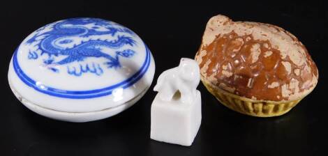 An 18thC miniature dish and cover, of oval form, with tortoiseshell type lid, 5cm W, a blue and white jar decorated with dragon and a blanc de chine seal. (3)