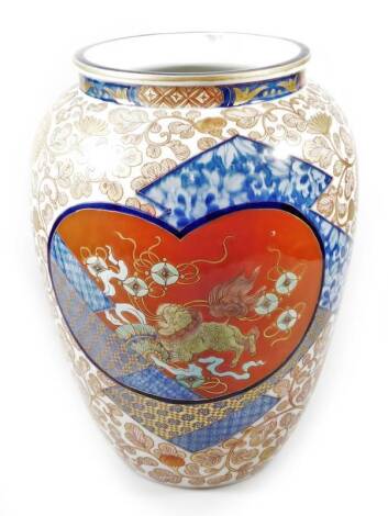 A 20thC Imari semi-porcelain vase, of circular form, decorated with panels of dragons broken by gilt highlighted flowers predominately in red, green and blue, Kangxi style floral mark beneath, but 20thC, 25cm H.