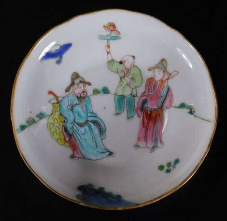 A late 19thC Japanese porcelain saucer, polychrome decorated with three figures, predominately in pink, green and blue, on a circular foot, seal mark beneath, 11cm W.