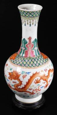 An 18thC Qianlong Chinese porcelain bottle vase, with inverted stem and bulbous body, decorated with five claw dragons, flowers and a repeat geometric banding, predominately in orange, green and yellow, on a circular foot, six character mark beneath, 24cm - 3