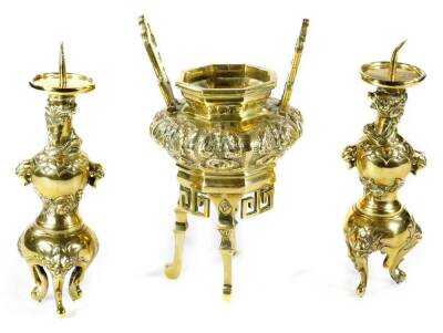 A Chinese polished bronze censer, with raised pierced handles and bombe body, repousée decorated with a repeat floral pattern, with pierced sections beneath, on elongated legs and scroll feet, 27cm H, and two candlestick garniture similar. (3)