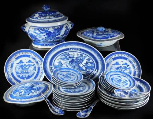 An 18thC Chinese export blue and white porcelain dinner service, to include lidded tureen, 25cm H, two lidded vegetable dishes, serving plate, ladles, further plates, dishes, side plates, etc., each decorated with buildings and trees with an outer geometr