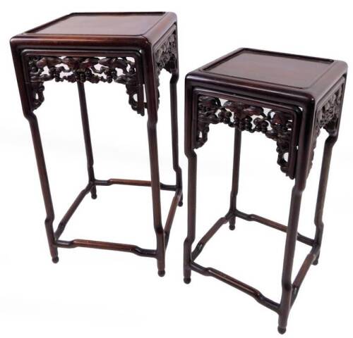 A nest of two Chinese Qing period tables, probably big leaf tan wood, each with plain square tops and bamboo style legs with a carved frieze of berries and leaves, on orb feet, the largest 63cm H, 31cm W, 31cm D. (2)