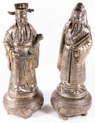 A pair of Chinese silvered metal figures, the first a bearded scholar in flowing robes on shaped base, the second a bearded sage holding fan, 44cm H. (2)