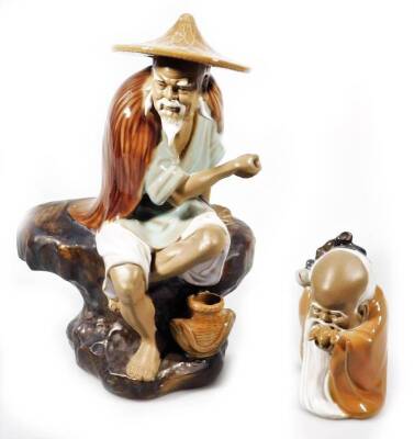 Two Chinese terracotta Ming style figures, the first in flowing robes on a rock work base aside vase, the second formed as a bearded sage, in subdued colours predominately in brown, white and blue, 10cm H. (2)