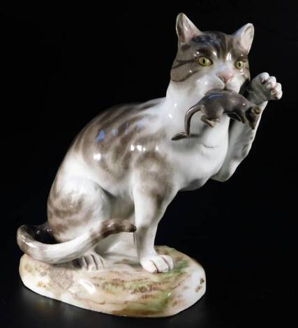 A 19thC Meissen porcelain figure of a cat, in standing pose with paw raised, with rat to mouth, in gilt highlights with cross sword mark beneath, 20cm H. (AF)