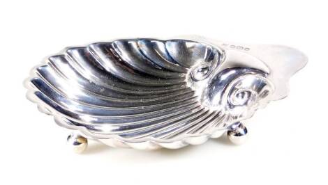 An Edwardian silver shell shaped butter dish, on orb feet, Sheffield 1907, 13cm W, 1½oz.