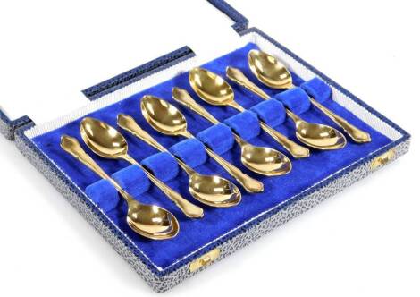 A set of eight Elizabeth II silver gilt teaspoons, with shaped handles, 11cm W, Sheffield 1976, 4½oz. (8 cased)