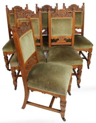 A set of six Victorian oak library or dining chairs, each with shaped top rails, overstuffed backs and seats in later green material, on part gadrooned turned front legs terminating in castors, 107cm H. (6)