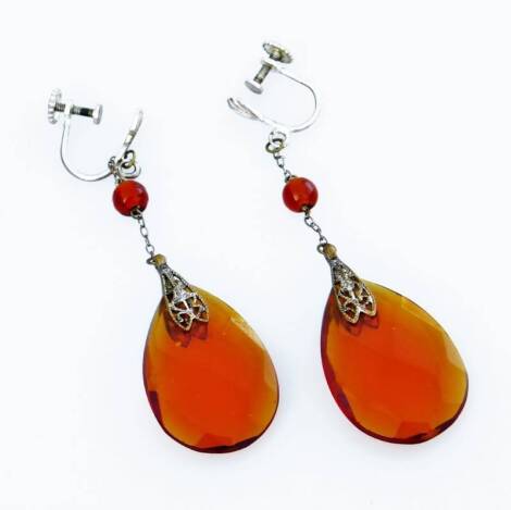 A pair of Art Deco style costume jewellery drop earrings, each with an orange coloured stone, and filigree designed clasps, screw backs, silver plated.