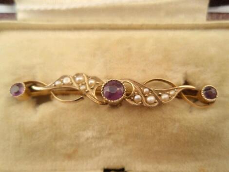 An Edwardian bar brooch set with seed pearls and 3 amethysts in a wave design