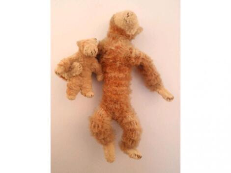 A miniature chenille bear holding a baby bear