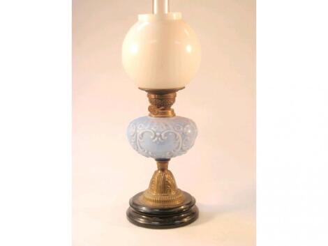 A 19thC oil lamp, with a blue opaque glass reservoir, moulded with scrolls