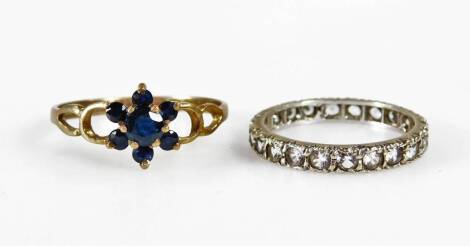 Two 9ct gold dress rings, comprising a blue stone set cluster ring, with pierced effect shoulders, ring size Q½, and a 9ct gold and silver white stone set eternity ring, ring size M½, 3.6g all in. (2 boxed)