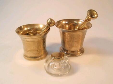 Two brass pestle and mortars and a glass inkwell with hinged lid