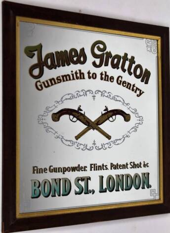 An advertising mirror, marked James Gratton Gunsmith to The Gentry Bond Street London, centred by two crossed pistols, 63cm x 57cm, framed.