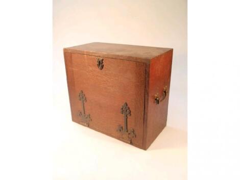 An oak coin collectors cabinet with a selection of drawers and fall flap