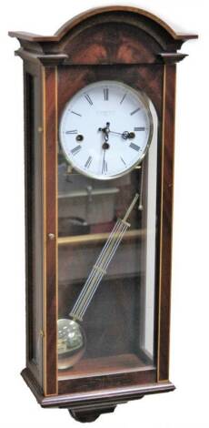 A 20thC Comitti mahogany cased chiming wall clock, the 14cm Dia. Roman numeric dial in a three part glazed case, revealing a quarter striking pendulum swung chiming movement, 60cm H.