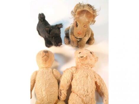 An early 20thC earless teddy bear; another example a black Scotty dog and a seat lion