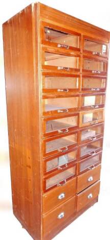 An early 20thC oak draper's cabinet, set with two banks of eight drawers, with four further enclosed drawers beneath, 199cm H, 1cm W, 53cm D.