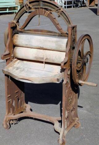 A 19thC Sharman & Ladbury mangle, with articulated plug top, circular handle and wooden rollers, on pierced stile supports joined by an inverted X stretcher, 153cm H, 91cm W, 50cm D.