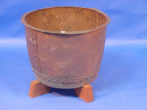 A large hammered and studded copper on a wooden stand