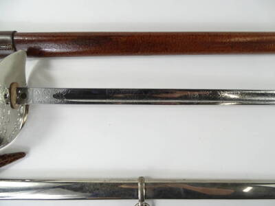 A George V dress sword, with an engraved blade, shark skin handle and pierced guard, housed within a brown leather scabbard with outer travelling case, sold with an accompanying plated scabbard, 101cm L. - 3