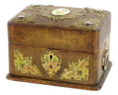 A Continental leather jewellery casket, the hinged lid applied with continental porcelain plaques, surrounded by engraved gilt brass cartouches, the base with two side handles and an elaborate lock plate (AF), 17cm W.