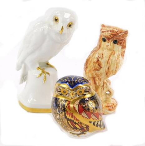 A Royal Crown Derby porcelain imari paperweight modelled as a Little Owl, Hutschenreuther porcelain figure of a white glazed owl perched on a bell shaped base, and an Alaskan native clay model of an owl with marbled decoration. (3)
