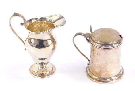 A George V silver mustard pot, of lidded drum form, Birmingham 1924, together with a baluster cream jug, Sheffield 1923, 6.65oz.