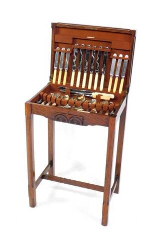 A 1930's oak table canteen of cutlery, by Joseph Rodgers & Sons Limited, Sheffield, containing Old English pattern flatware, raised on fluted square legs united by an H frame stretcher, 68.5cm H. 46.5cm W, 33.5cm D.