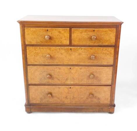 A Victorian mahogany and burr walnut chest of drawers, with two short over three long drawers raised on a plinth base over turned feet.