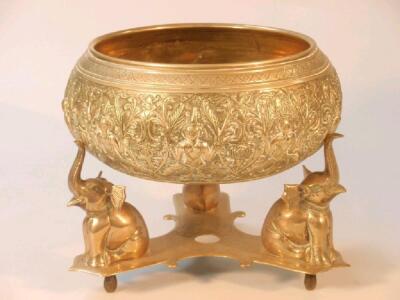 An Indian brass bowl on a triform elephant stand