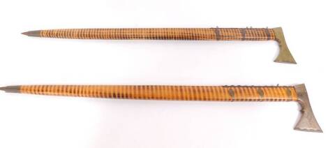 A near pair of Polish or Slovakian shepherd's axes, or Valaska, with wooden shafts, one with a steel tomahawk axe head, the other with a brass axe head, spike tipped, 90cm and 80cm long.