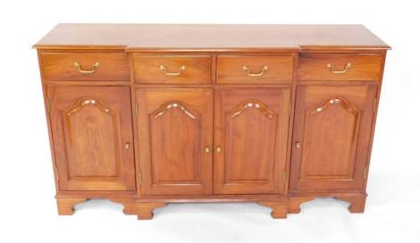 A mahogany breakfront sideboard, with four drawers over four doors, raised on bracket feet.