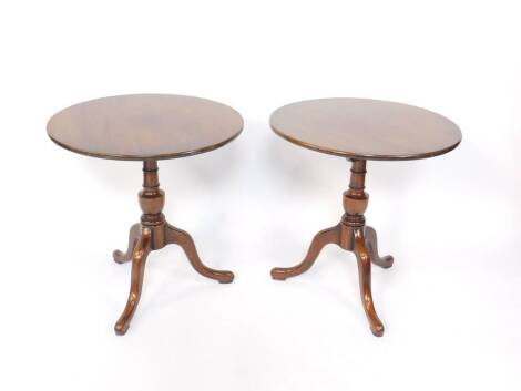 A pair of Georgian style mahogany occasional tables, the circular tops raised on a turned column over three cabriole legs, 69cm H, 67cm Dia.