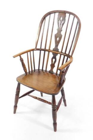 A 19thC oak and elm stick back Windsor chair, with a carved splat, solid seat, raised on turned legs.