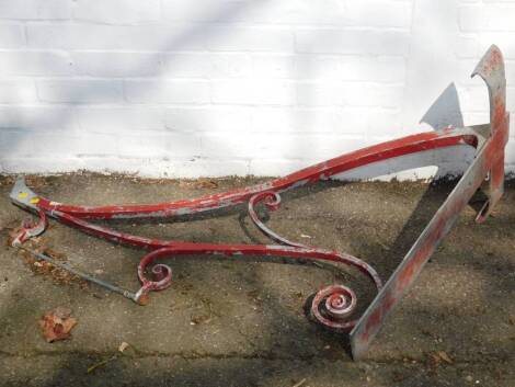 A red painted metal pub sign bracket, of scrolling form, 110cm W, 78.5cm H.