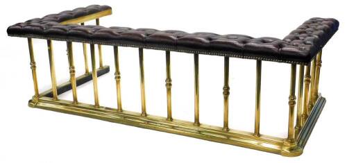 A 20thC brass club fender, with a brass buttoned leather top, embellished with brass studs, on turned rails with moulded base, 184cm W, 54cm H, internal measurements 148cm x 71cm.