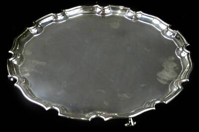 An Elizabeth II silver salver, with a piecrust border and scroll feet, Sheffield 1967, retailed by Usher of Lincoln, 26¼oz, 31cm dia.