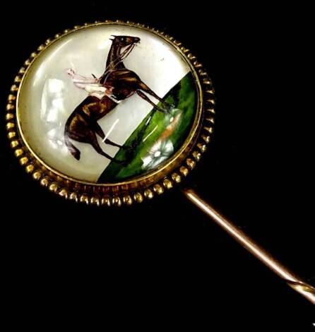 An Essex crystal stick pin, with circular pin head depicting a figure on horseback, 2cm dia, with beaded border, yellow metal, unmarked, boxed, 8cm H.