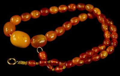 A butterscotch amber beaded necklace, of graduated form, on string strand, 39cm long overall, 9.5g all in.