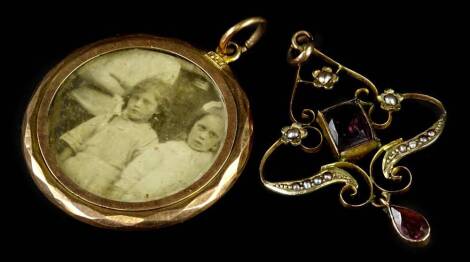 An Art Nouveau pendant and a gilt metal pendant, the Art Nouveau pendant set with amethyst and seed pear, yellow metal, marked 9ct, 4cm H, 2.1g all in, and a circular gilt metal portrait locket. (2)