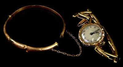 Two items of jewellery, to include a ladies wristwatch with 9ct gold circular watch head and gold plated expanding bracelet, and a 9ct gold hinged bangle. (AF)