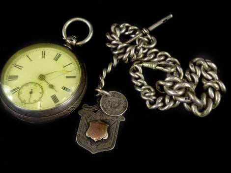 A silver pocket watch and chain, the pocket watch with white enamel dial, key wind, with curb link silver watch chain, and shield fob.