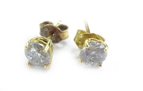 A pair of diamond stud earrings, each stone approximately 0.3cts, in yellow metal claw setting, marked 750.