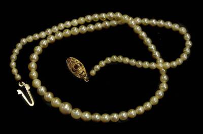 A single strand cultured pearl necklace, with a yellow metal clasp, with an 18ct gold clasp, set with ruby, the graduated pearls, the largest 7mm W, the smallest 2mm W, 44cm L overall.