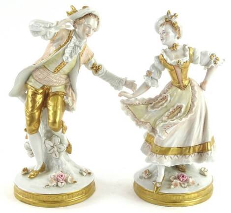 A pair of German porcelain figures, each modelled in the form of a gentleman and lady with flower encrusted bases picked out in gilt, 19cm H.